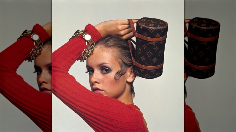 Twiggy poses for a photoshoot wearing blue eyeshadow and a red top