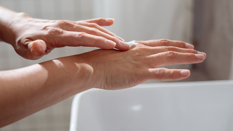 woman applying lotion on hand