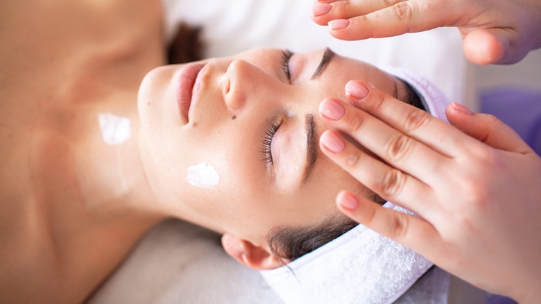 dermatologist prepping woman's skin for facial treatment
