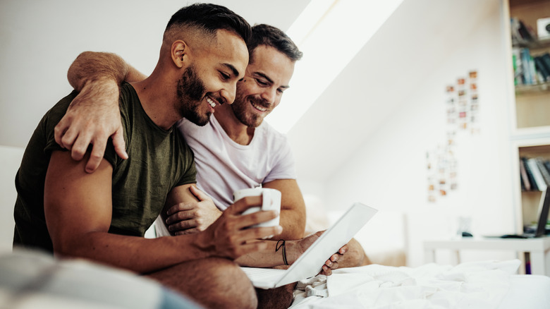 Happy gay couple using laptop