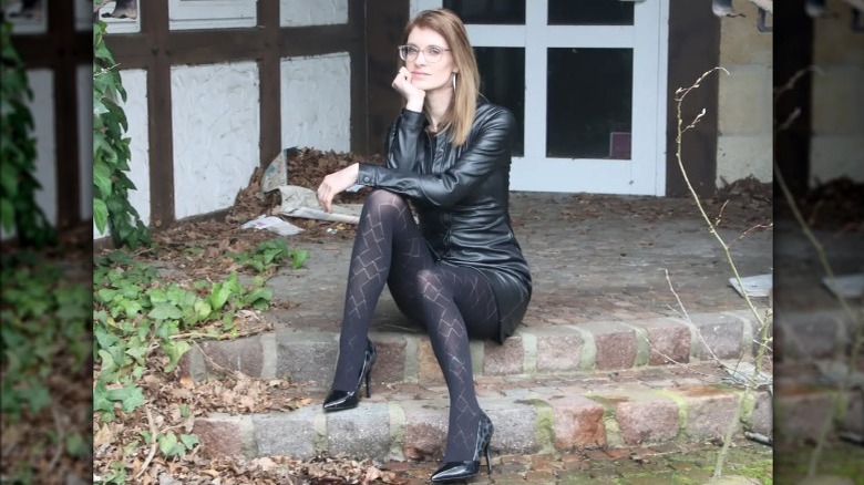 Woman sitting, wearing black tights