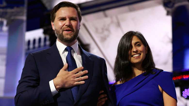 JD Vance clutching his chest while standing beside Usha Vance