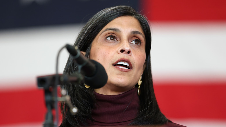 Usha Vance speaking at a microphone in front of a red, white, and blue background.