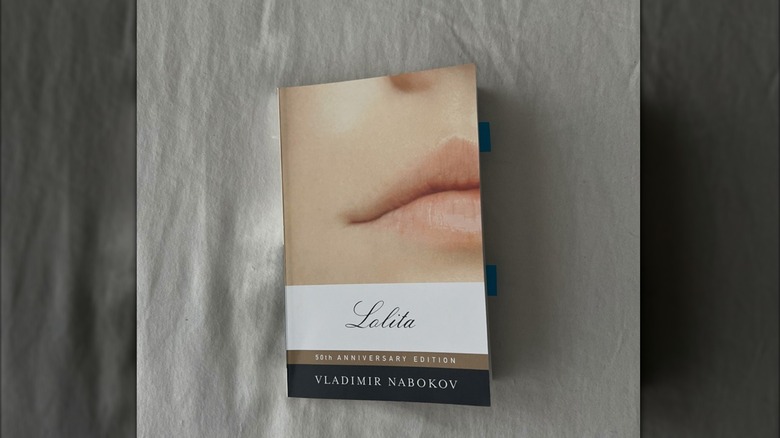 The book 'Lolita' by Vladimir Nabokov lays flat on a white linen sheet
