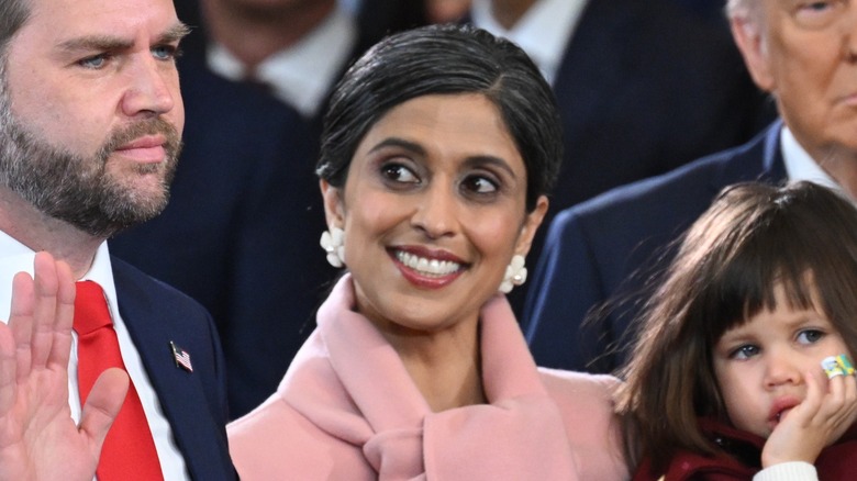 Usha Vance smiling in a pink wool coat and huge earrings