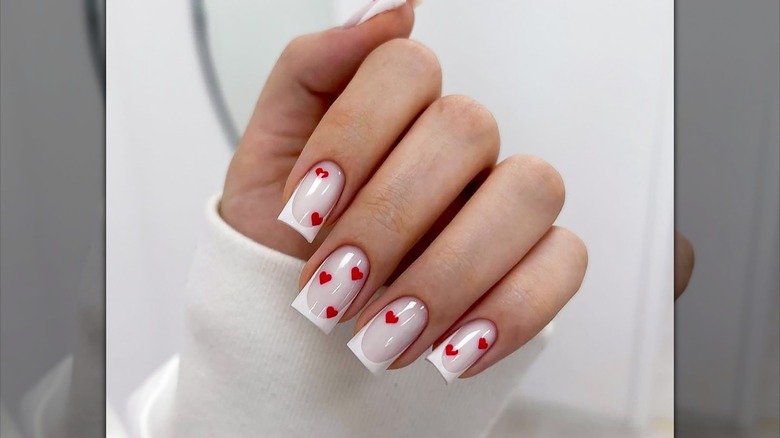 Nail art with with tiny red hearts