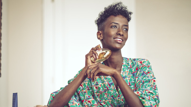 Woman putting on perfume