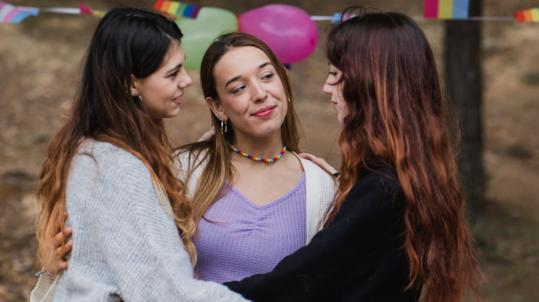 Three women holding each other lovingly