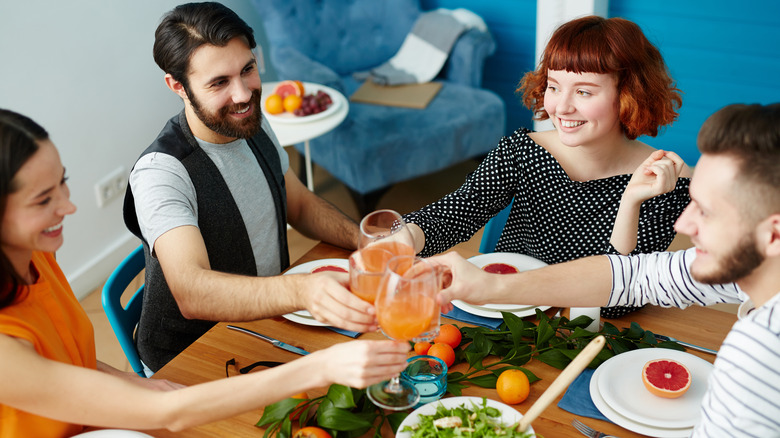Four people eating dinner, toasting