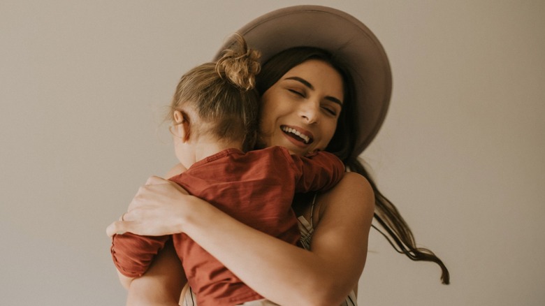 A woman holds her toddler.