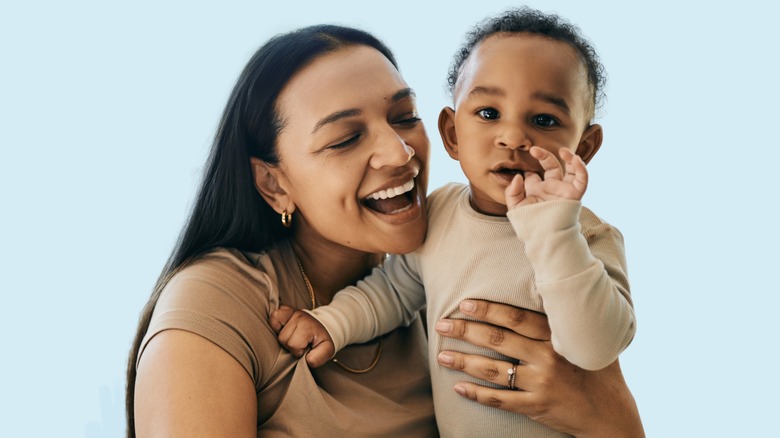 A woman holds a child.