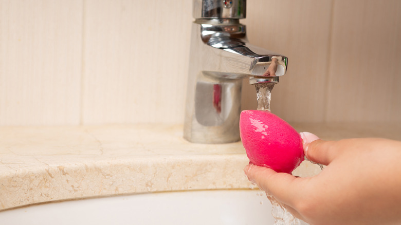 Woman soaking a beauty blender