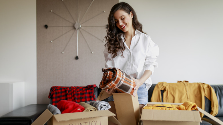woman organizing clothing in boxes
