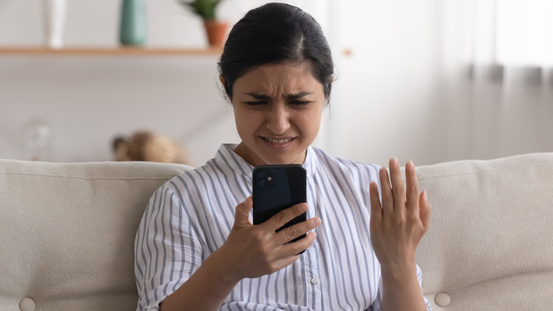 confused woman holding phone