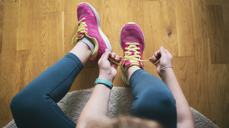 A woman putting on her sneakers