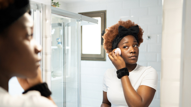 Woman blending foundation in with a sponge