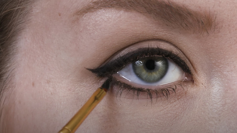 person applying winged liner