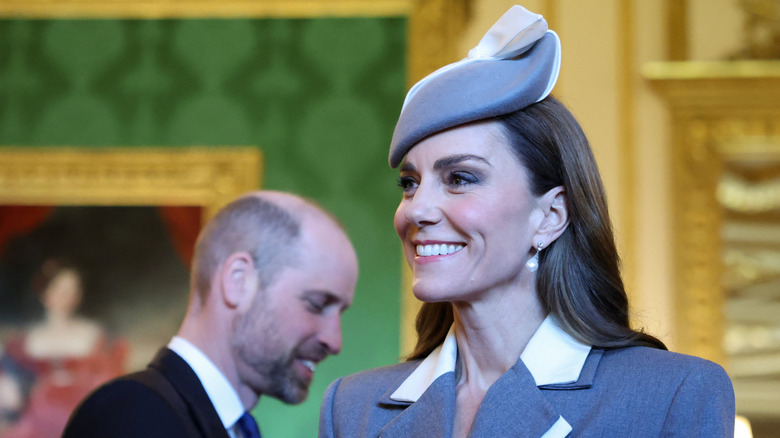 Kate Middleton in a fascinator and matching gray suit with soft glam makeup