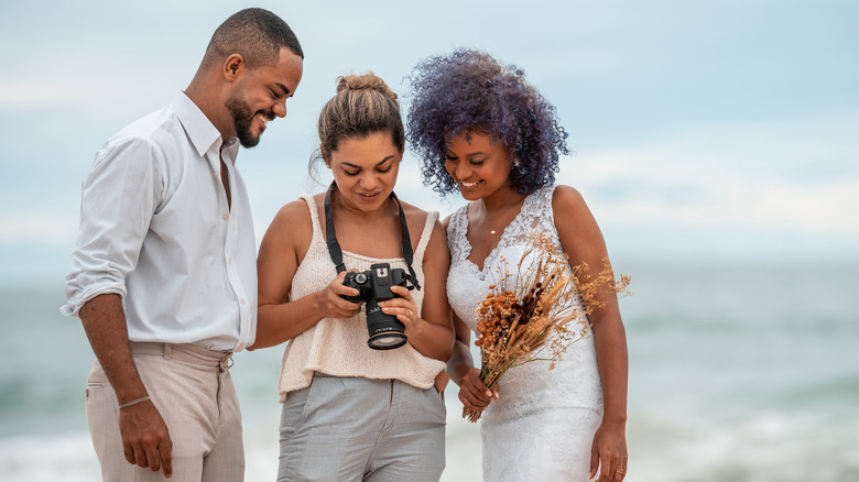 Wedding photographer with bride and groom