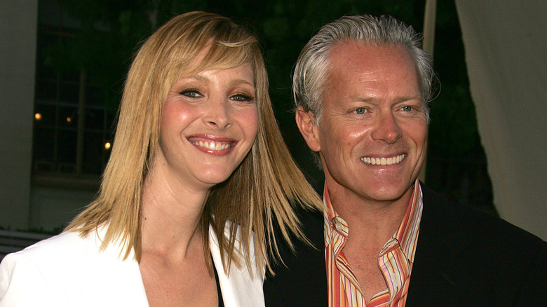 Lisa Kudrow wearing a white blazer posing with husband Michael Stern