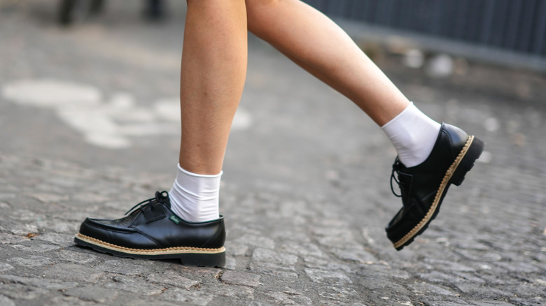 Someone walking in derby shoes and socks