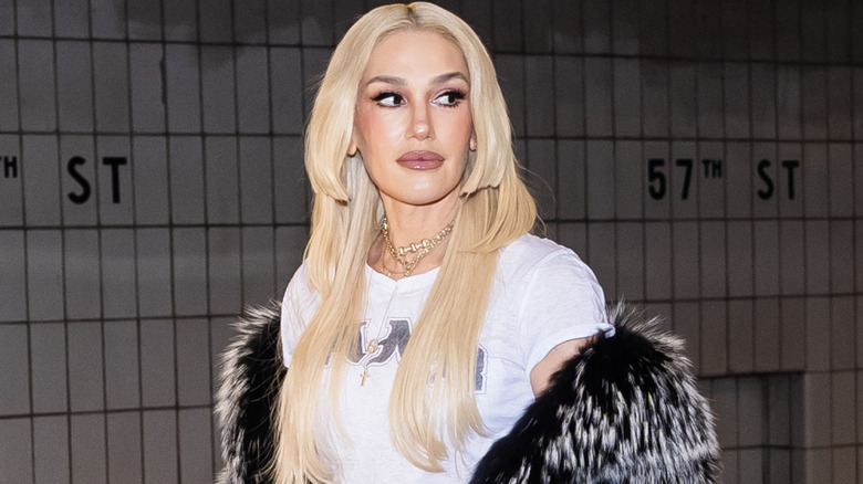 Gwen Stefani posing in a white T-shirt with a fur shawl