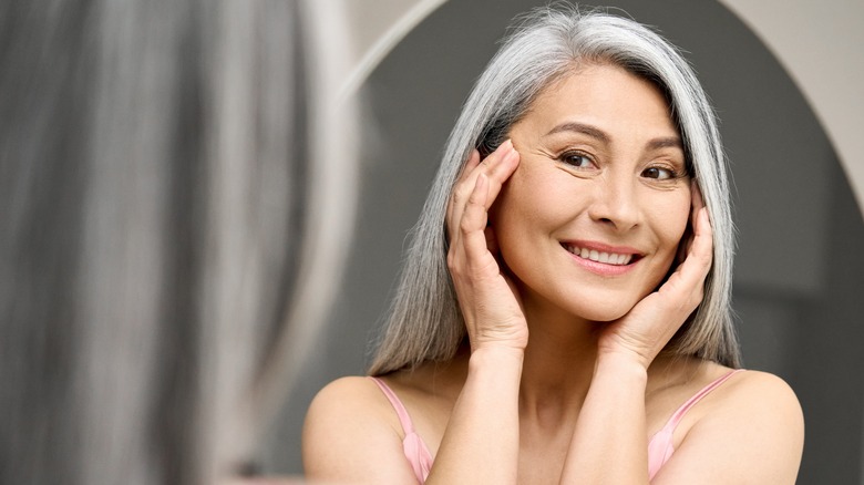 Woman admires her skin in the mirror