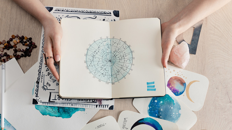 young woman holding birth chart drawing