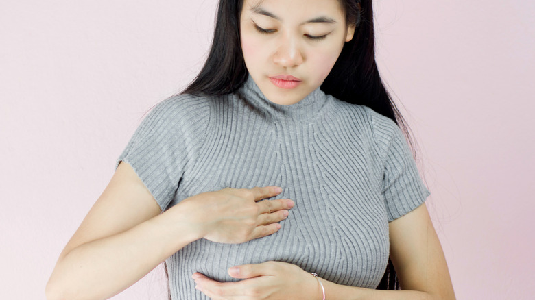 female examining breast lump