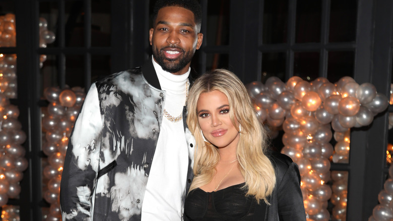 Tristan and Khloe smile in front of balloons