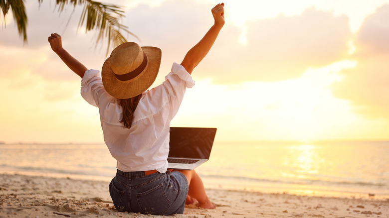 Woman on beach with laptop