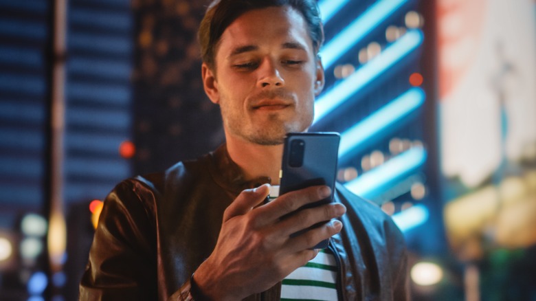 man texting at night in the city