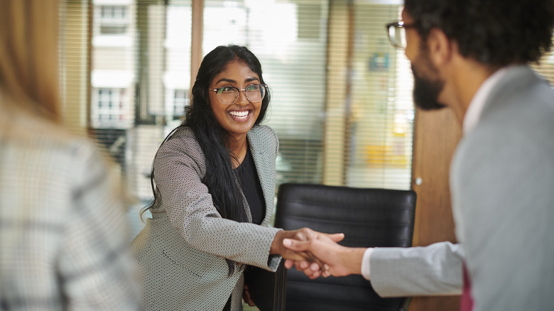 woman and man shaking hands 