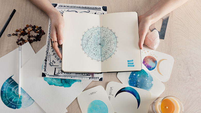 astrologer with a notebook and cards with horoscopes