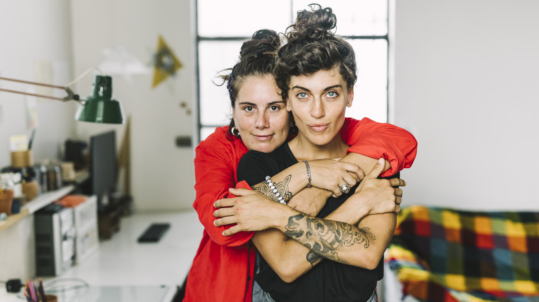 hugging women with tattoos