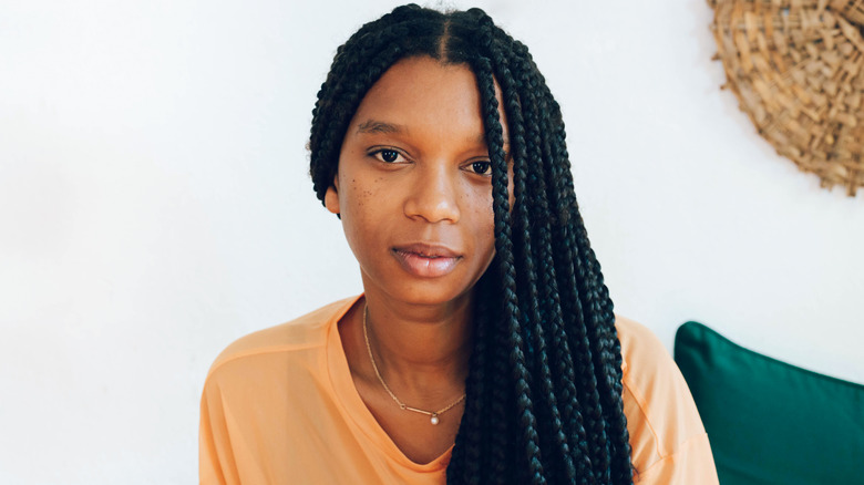 A woman with hang-down braids sitting