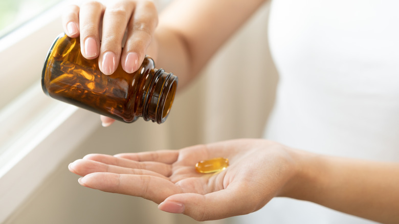 Someone pouring a supplement into their hand