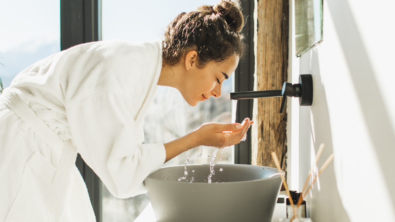 A woman washing her face.
