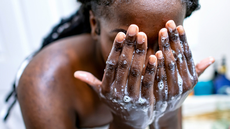 A woman washing her face.