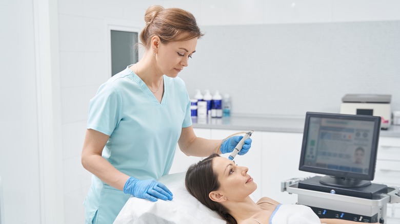 woman performing hydrafacial 