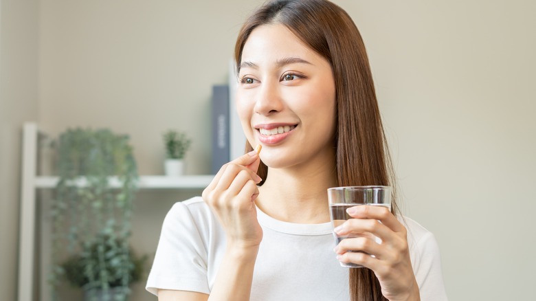 woman taking vitamin C supplement 