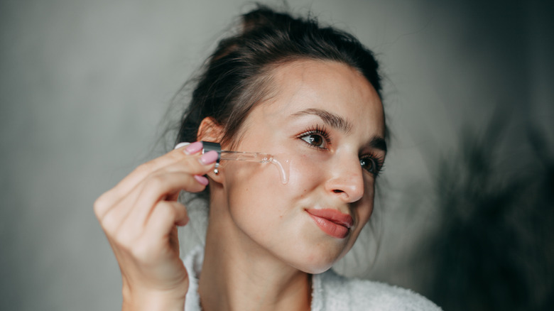 woman applying facial serum 