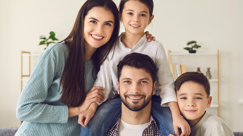 family of four smiling happily 