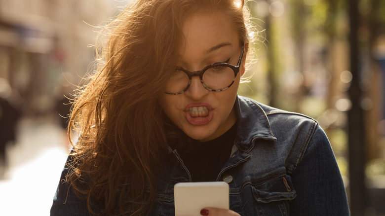 angry woman holding cell phone