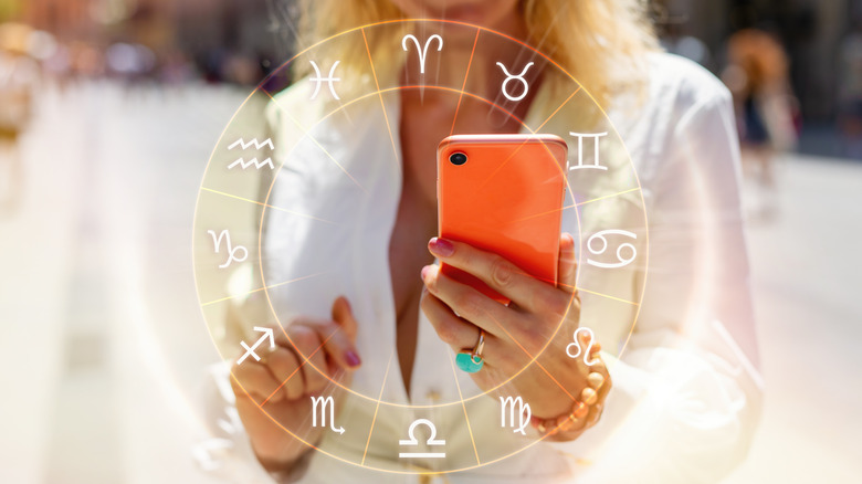 Woman reading zodiac signs on her phone