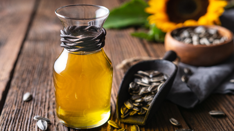 Sunflower oil in glass jar next to sunflower seeds