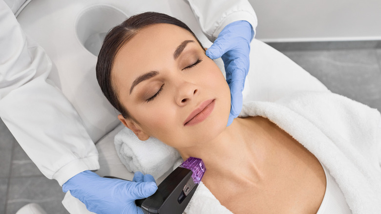 A woman getting a neck treatment done