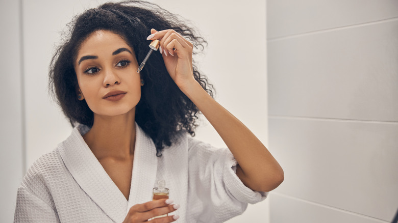 woman putting skin oil on