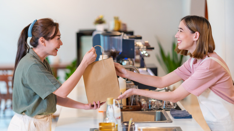 Worker handing customer food bag