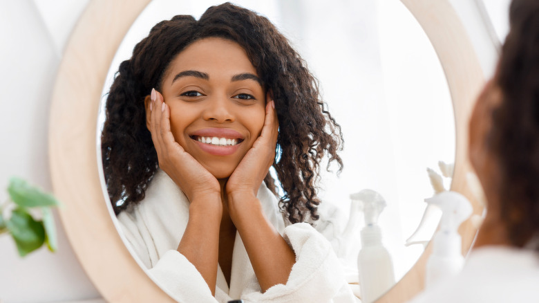 woman happily looking in mirror
